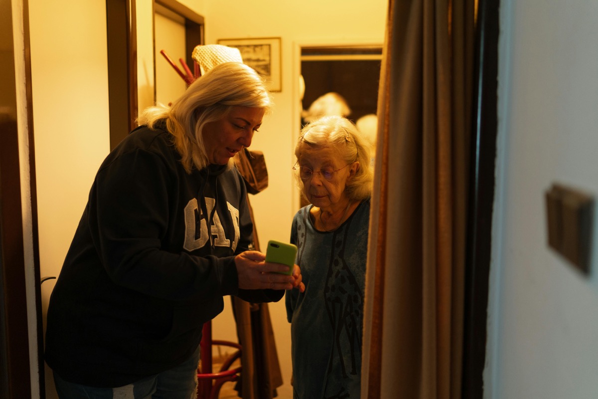 スマートフォンの使い方を支援するスタッフと利用者